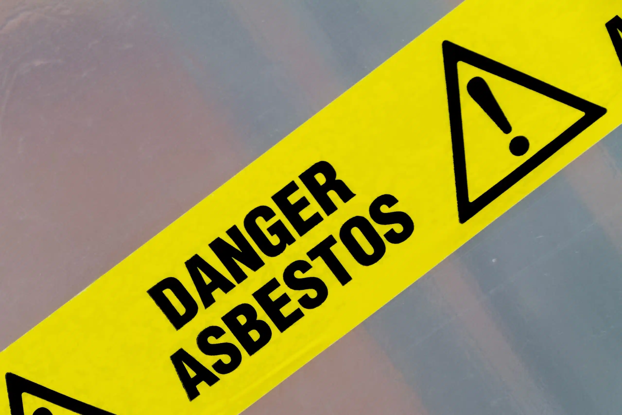 Yellow asbestos hazard warning sign with exclamation mark