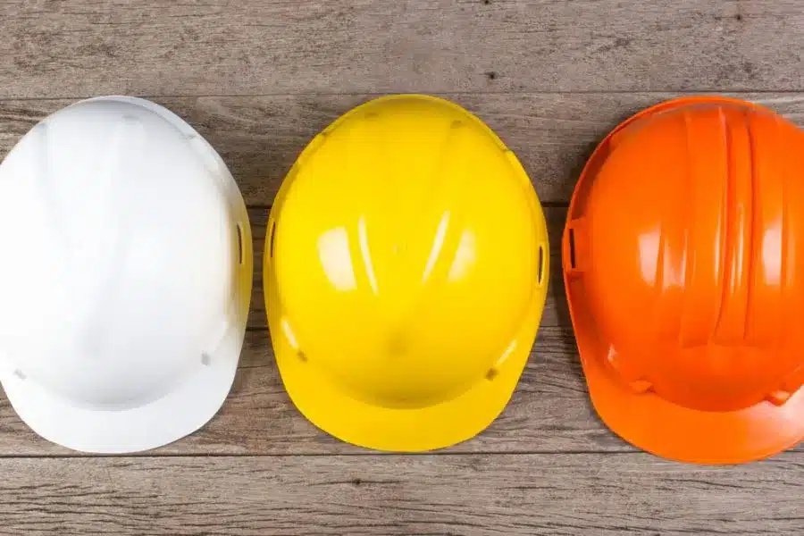 Three construciton workers hard hats as worn by CSCS laboureres