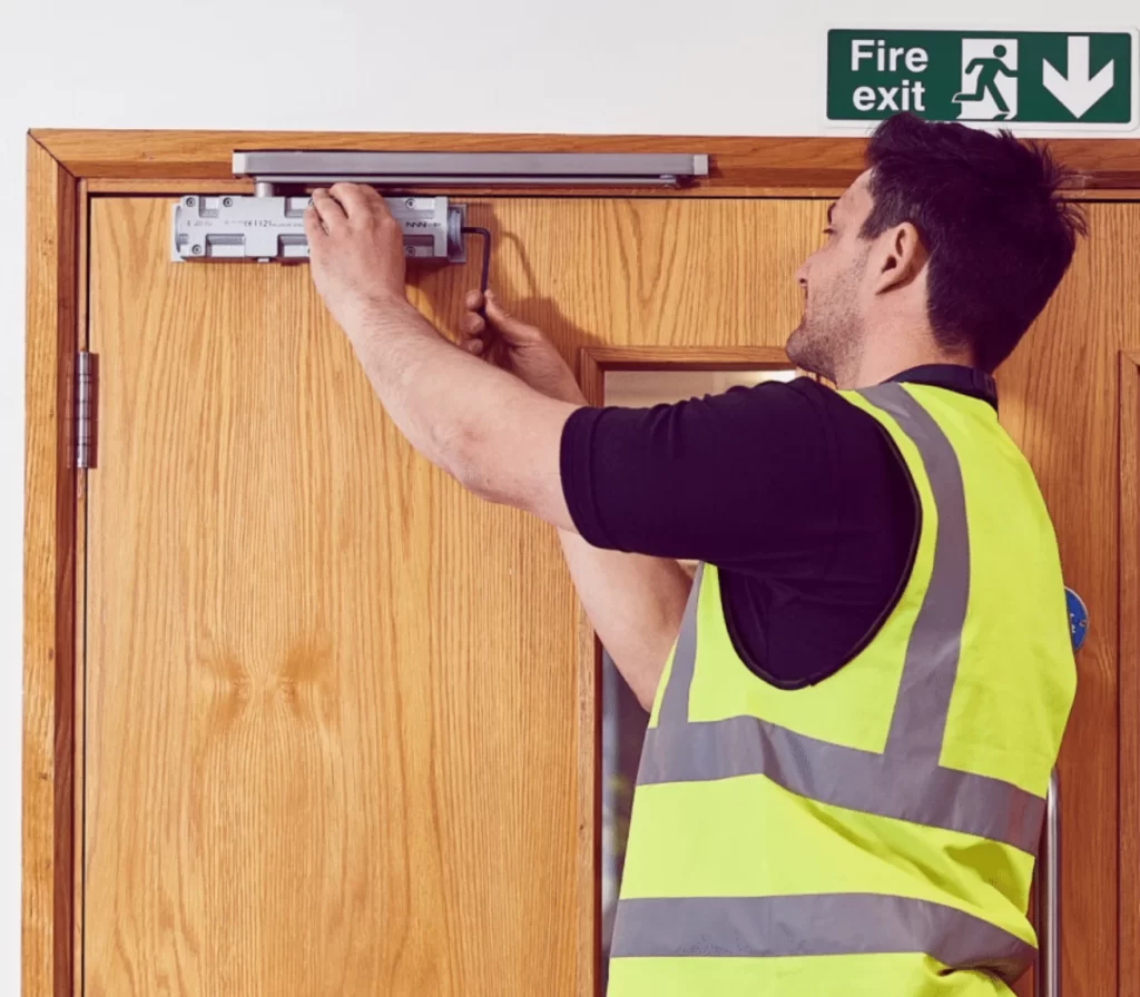 Man installing a fire door as part of practical training for an online fire door installation course