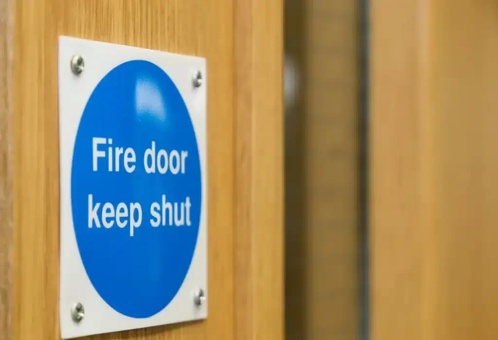Graphic showing a professional inspecting a fire door